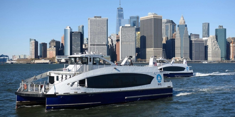 Two NYC Ferries crossing in front of Downtown NYC