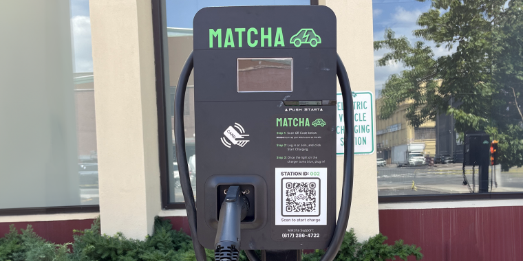 Matcha Electric vehicle charging station with a QR code for starting a charge, and a plugged-in charging cable, outside of the Brooklyn Army Terminal.